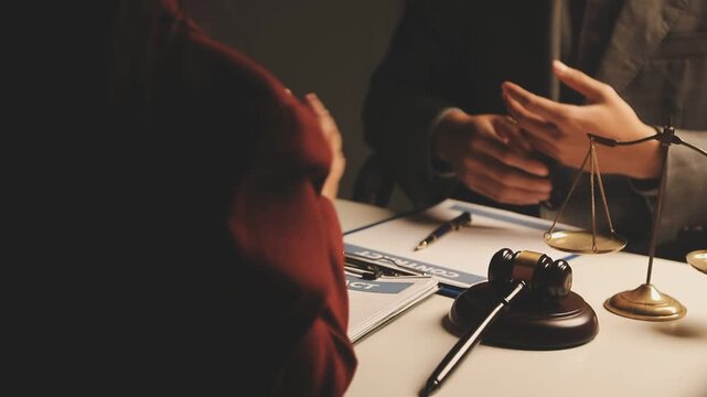 Legal advisor is explaining the offense under the law in the book at office.