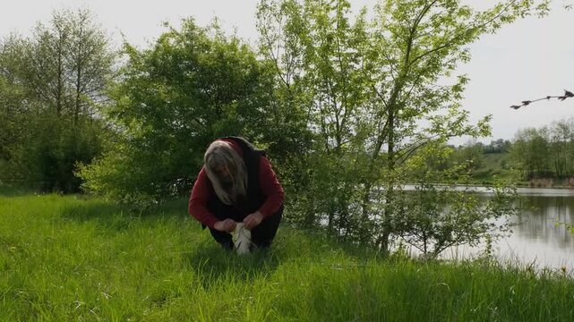 Successful carp fishing on a sunny river bank with senior woman