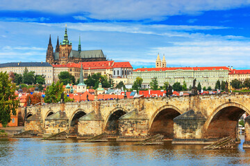 Obraz premium Charles Bridge (Karlův most) in Prague, Czech Republic, spanning the Vltava River with historic towers and Gothic architecture. Panoramic view of the medieval bridge and city skyline, iconic European 