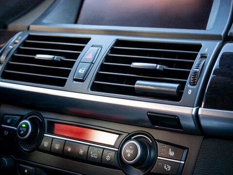 Car air conditioning system dashboard controls and air vents for comfortable temperature regulation inside vehicle interior. Modern auto climate control console.