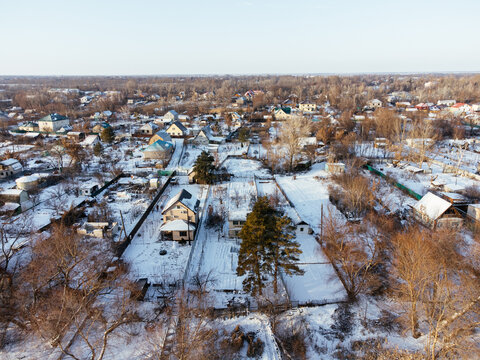 Aerial view of snow-covered houses near frozen river in Uralsk, Kazakhstan, during winter. c.