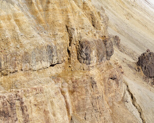 Obraz premium Detailed texture of eroding volcanic canyon walls with yellow sulfur rocks in the Grand Canyon of the Yellowstone, Wyoming, USA