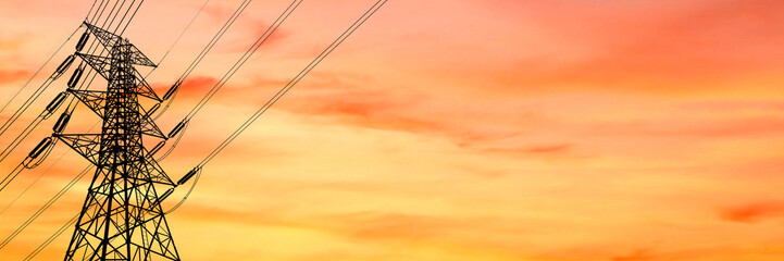 High voltage pylon and power lines against a vibrant sunset sky. The metal structure contrasts beautifully with the warm colors © Stock4u2024 