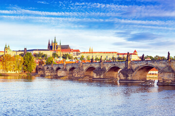 Obraz premium Charles Bridge (Karlův most) in Prague, Czech Republic, spanning the Vltava River with historic towers and Gothic architecture. Panoramic view of the medieval bridge and city skyline, iconic European 