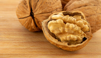 Walnut kernels and whole walnuts on wooden table