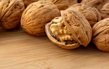 Walnut kernels and whole walnuts on wooden table