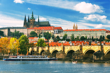 Obraz premium Charles Bridge (Karlův most) in Prague, Czech Republic, spanning the Vltava River with historic towers and Gothic architecture. Panoramic view of the medieval bridge and city skyline, iconic European 
