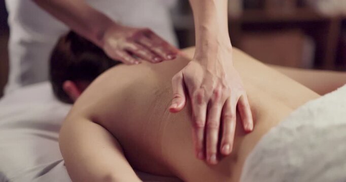 Massage therapist hands on woman back in spa. Session enhances relaxation and wellness, easing tension and improving circulation for better body therapy. Relaxing back massage wellness concept.