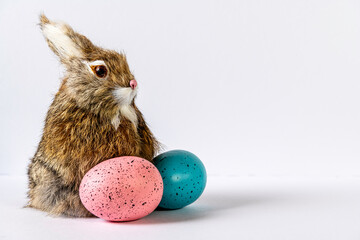 bunny with pink and blue Easter eggs on white background