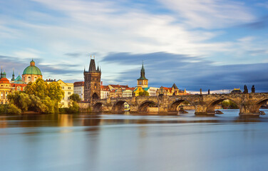 Naklejka premium Charles Bridge (Karlův most) in Prague, Czech Republic, spanning the Vltava River with historic towers and Gothic architecture. Panoramic view of the medieval bridge and city skyline, iconic European 