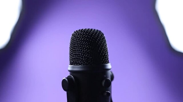 Close-up of a microphone on a stage with purple lighting, ready for a performance or recording session.