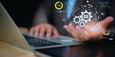 Artificial general intelligence interface over businessman hand using laptop, digital dashboard hologram, data analytics, automation and machine learning technology for future business innovation.