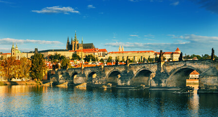 Obraz premium Charles Bridge (Karlův most) in Prague, Czech Republic, spanning the Vltava River with historic towers and Gothic architecture. Panoramic view of the medieval bridge and city skyline, iconic European 