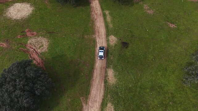 Police Patrol Car Driving Through Dehesa Countryside, Protecting Natural Environment and Preventing Environmental Crimes