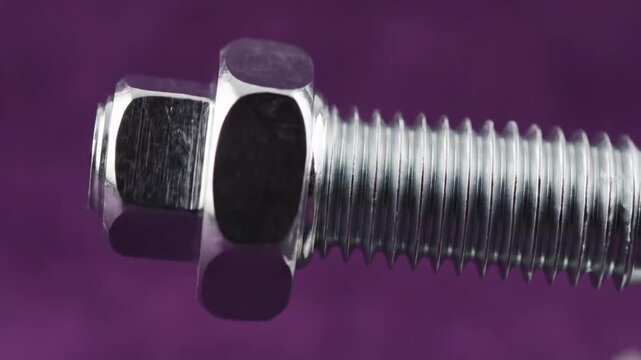 Close-up of a Shiny Metal Bolt and Nut on a Vibrant Purple Background.