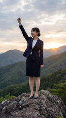 山頂でガッツポーズをするOL
