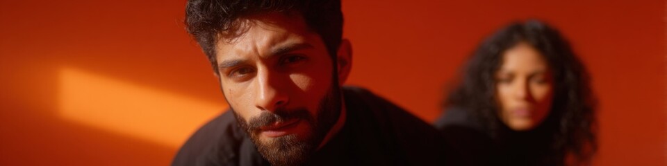 Obraz premium Young hispanic male and female in intense orange lighting