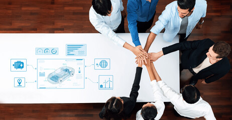 Diverse group of professionals collaborating over automotive data analysis. They engage in...