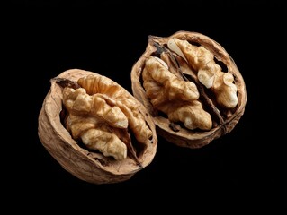Obraz premium walnuts cracked open showing interior isolated on a black background