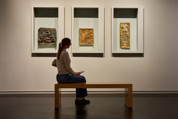 visitor in historical museum looking at art object