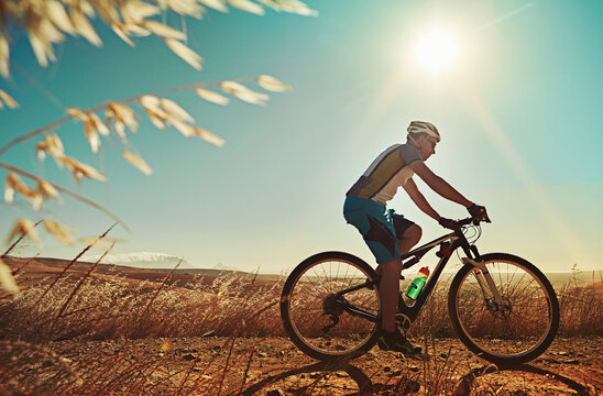 Countryside, bike and man with fitness, travel or hobby with journey, nature or endurance. Cyclist, transport or person with bicycle, training or helmet for safety, sunshine or challenge in Australia