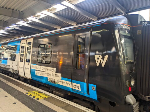 West Midlands Railway Class 350 train at London Euston station platform with Mind the Gap sign