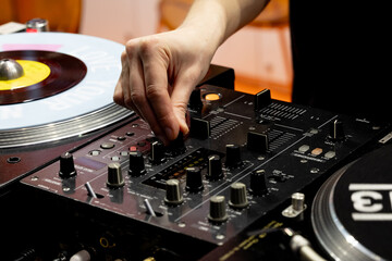 Obraz premium A DJ creates music at a party. The DJ's hand controls the sound at a party.