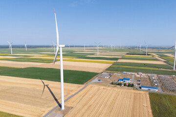 Obraz premium Aerial view of wind turbines with electric power station