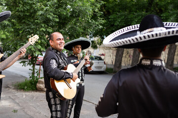 Fototapeta premium Mexican musicians mariachi wearing traditional suits with sombrero on the city street