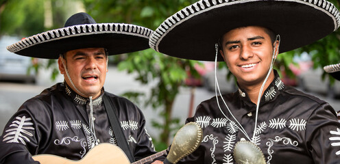 Mexican musicians mariachi wearing traditional suits with sombrero on the city street
