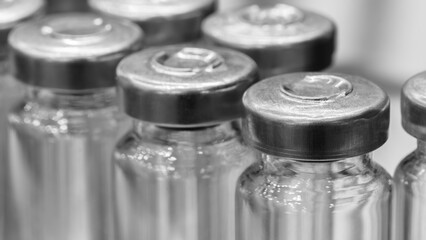 Professional medical glass vials for storing medicines and laboratory research of vaccines close-up at a pharmaceutical factory or hospital