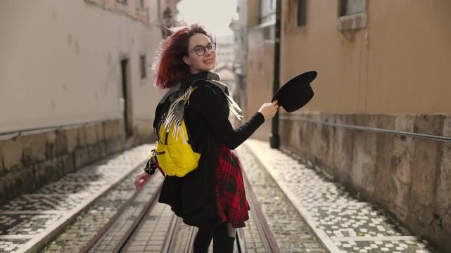 Happy young woman dancing on funicular tracks