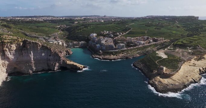 Aerial view of the captivating Xlendi Bay, where turquoise waters meet the rugged cliffs and the charming village, Xlendi, Munxar, Malta.