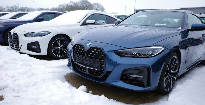 Wardenburg, Germany - Feb 6 2026 A dark blue metallic and a white BMW 420 Coup&eacute; are parked in the snow