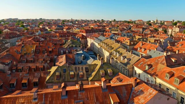 Vibrant European cityscape with terracotta rooftops under clear blue sky - 4k video