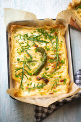 Savory asparagus puff pastry pie in baking dish, top view