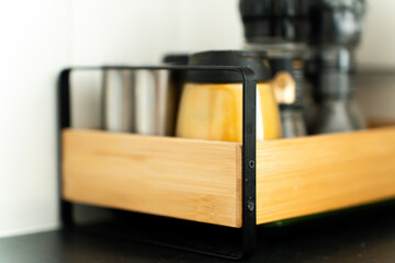 A close-up of kitchen spice rack with beautiful depth of field focused on the object. Assorted spice jars neatly arranged on a wooden stand, showcasing culinary ingredients.