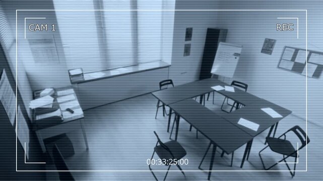 Security camera footage of empty classroom interior with desks and supplies waiting for students in prison education program, no people
