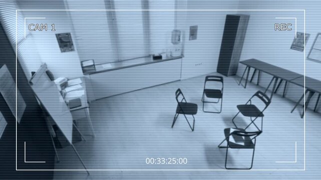 Security camera footage of empty support group meeting room with chairs arranged in circle at correctional facility, wide angle
