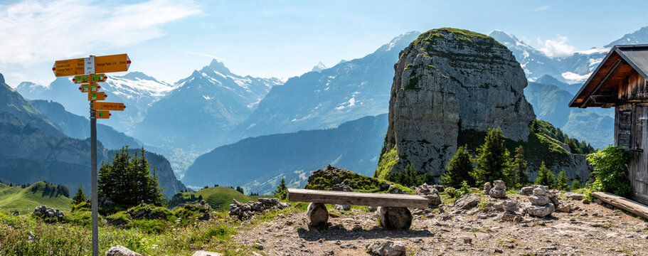 Hiking signs at the Schynige Platte, iconic mountains Eiger and Moench in the background