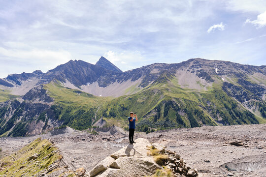 Young man searching for mobile phone coverage in the mountains