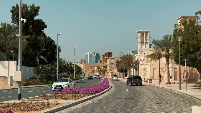 Driving montage contrasting Dubai&rsquo;s futuristic downtown skyline, with modern skyscrapers and traffic, against the charming traditional architecture 
