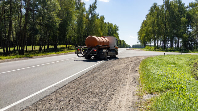 Sewage truck in motion on a forest road. Vacuum truck for wastewater treatment. Waste distribution and utilization policy concept