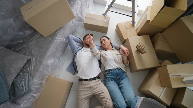 Couple laying on floor planning new home interior design
