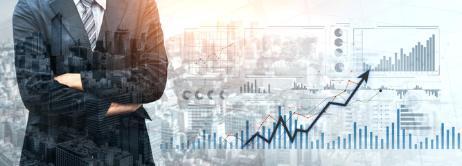 Business professional poses confidently before a digital financial dashboard. Skyline and graphs...
