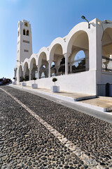 Iconic white church and cobblestone path under clear sky.