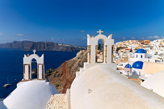 Santorini's iconic white churches, blue domes, and caldera view.