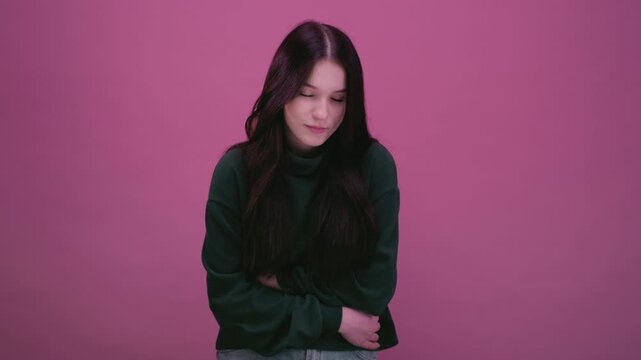 Teenage girl feels abdominal pain. White woman with black hair squeezing belly with hands. Suffering stomach. The young female starts menstruating. Teenager complains of terrible stomach pains.