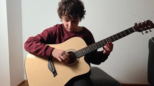 Teen boy playing guitar, music lesson concept and hobbies
