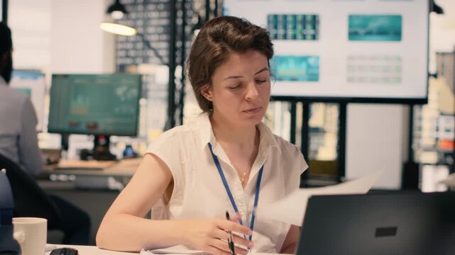 Businesswoman focused on writing detailed report at office desk, summarizing updates, organizing the agenda and drafting insights for the task management plans. Strategic planning.